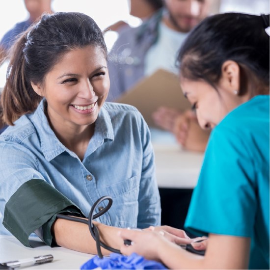 nurse taking blood pressure with smiling patient